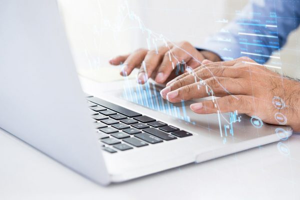 Businessman using online trading technology on laptop computer searching for digital data of stock for investment